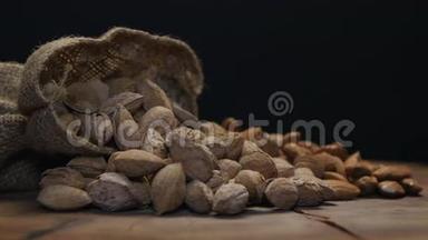 两堆杏仁装在贝壳里，壳在一张木桌上，被隔离在黑色上